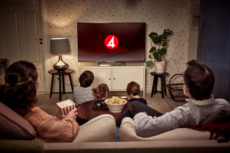 Familj som sitter i soffan och tittar på TV4